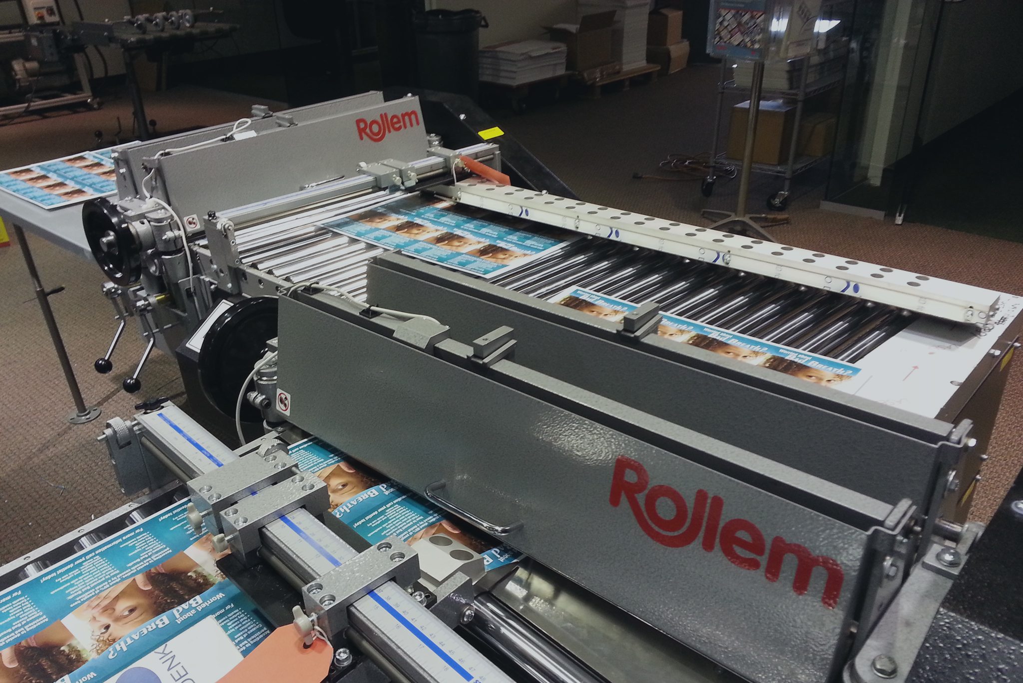 Official Rollem photo of the Jetstream XY bi-directional system (two Rollaway-type shaft-head units at 90°) processing multi-up dental postcards.