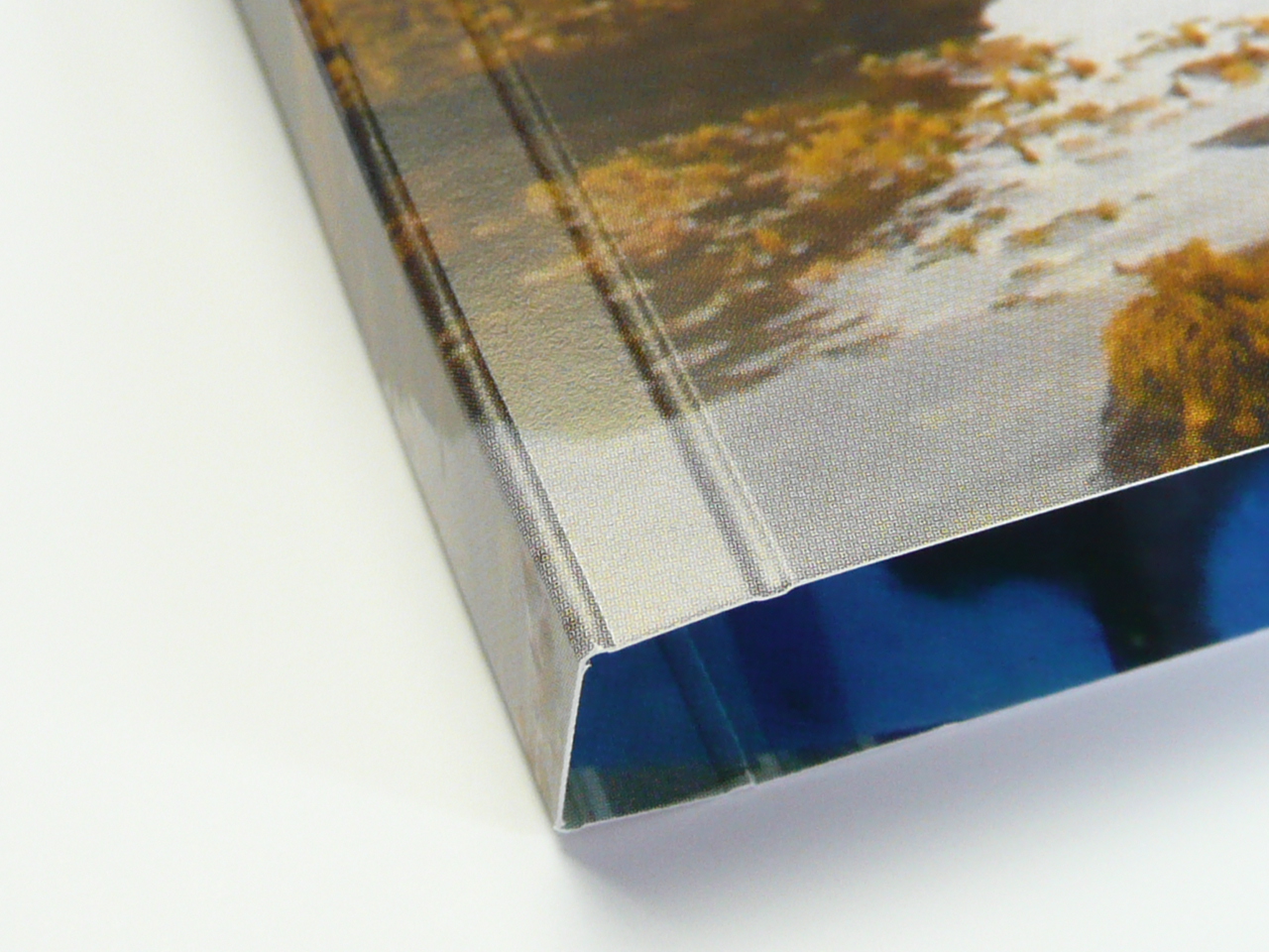 Finished book cover corner with crisp spine and hinge creases through printed artwork