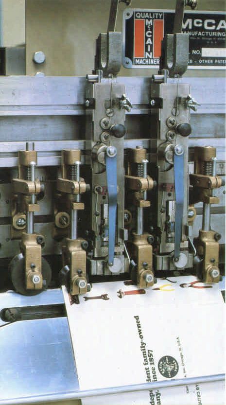 McCain 2000 Speedbinder stitching-head bank with McCain nameplate — official brochure photo (orientation corrected; OEM defunct)