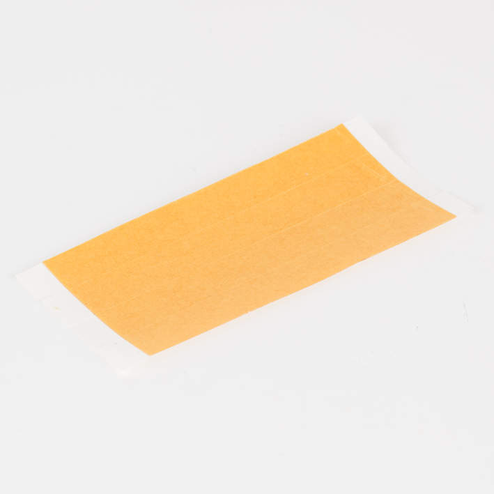 Sheet of orange self-adhesive tabs on white studio background