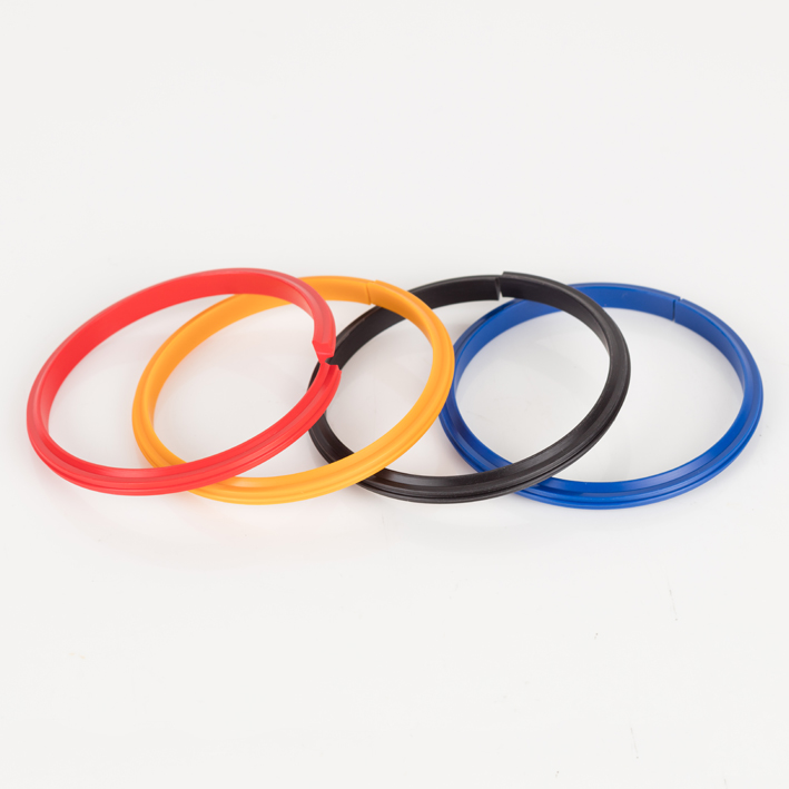 Four split plastic creaser bands, red orange black blue, overlapping