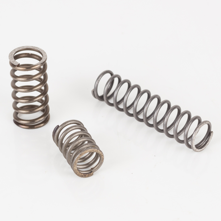 Three steel compression pressure springs of differing sizes