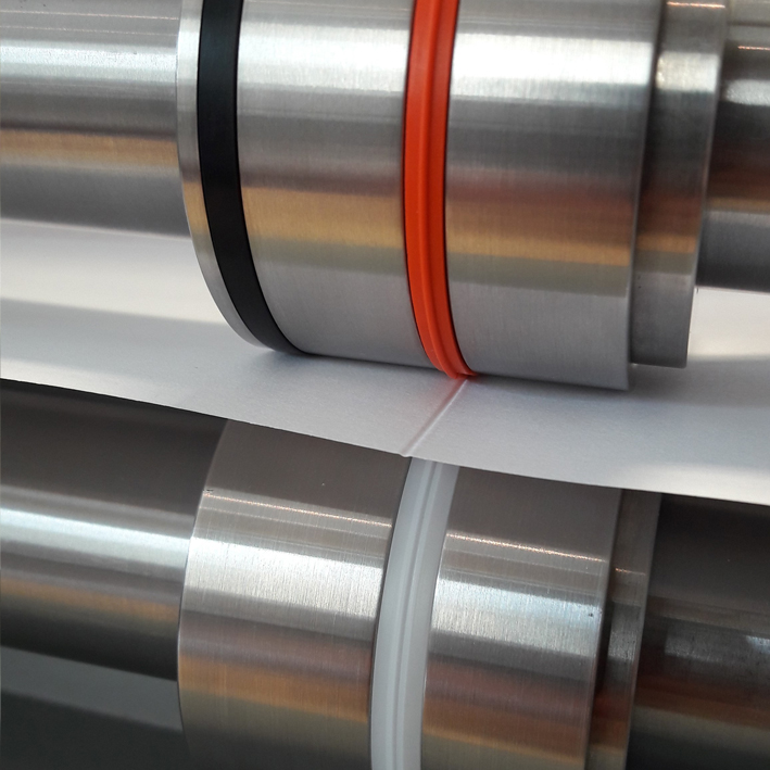 Fast-Fit tools with black and orange ribs creasing paper between machine shafts