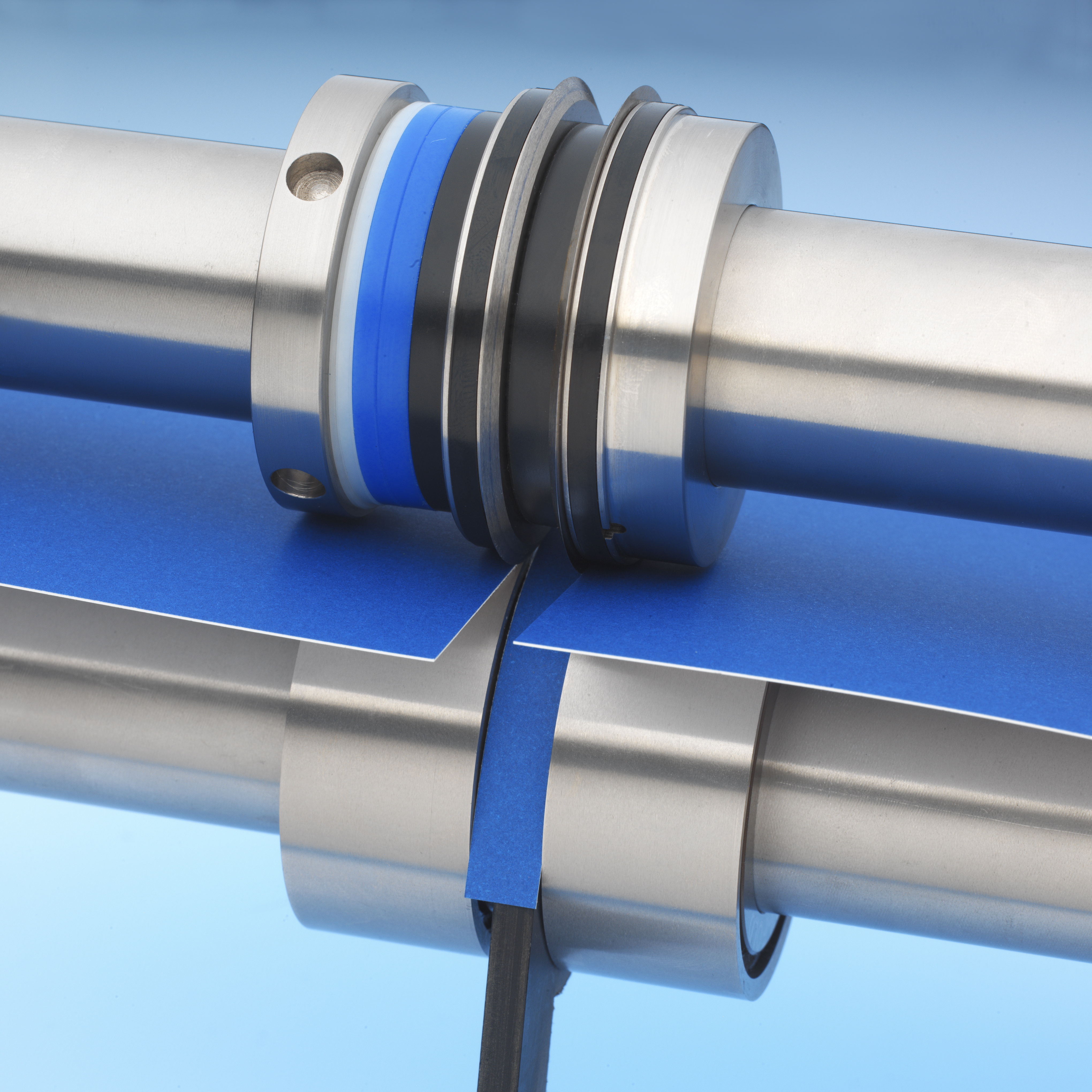 Male and female cutting collars slitting blue sheet on shafts