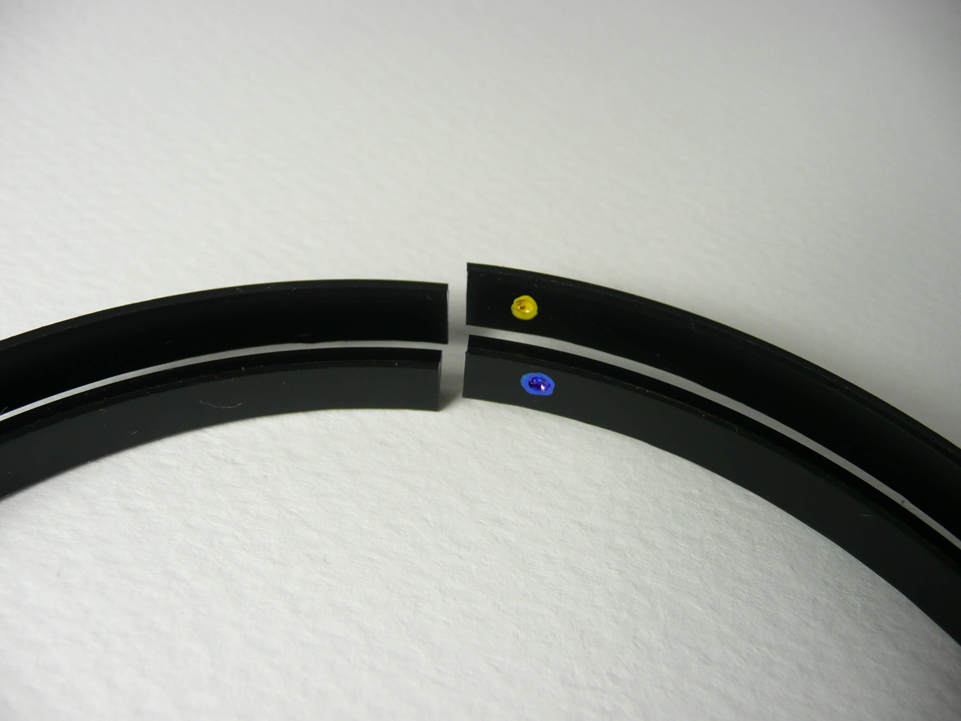 Two black nylon ribs close-up with yellow and blue dot markers