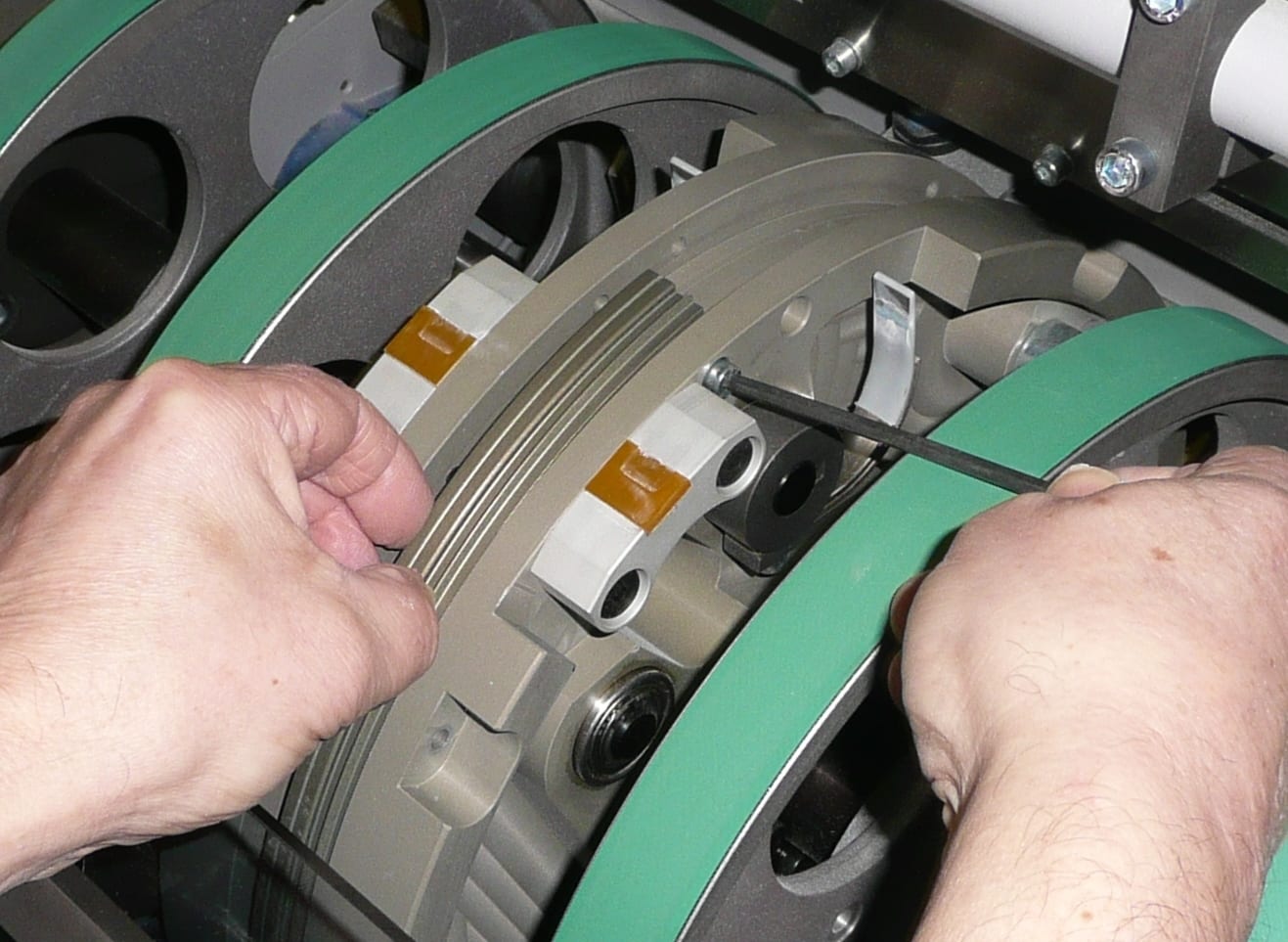 Fitting the segmented Spine-Creaser ring to the drum with hex keys, between the belts